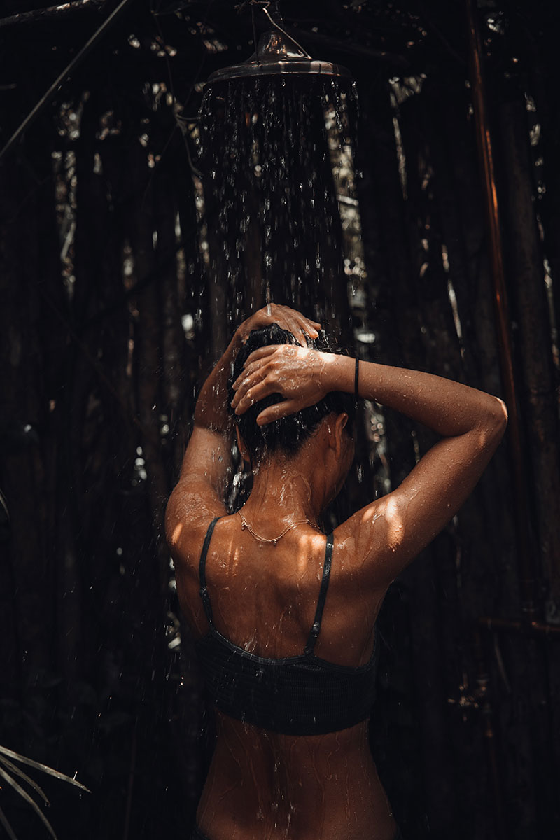 Mujer tomando una ducha para el cuidado de tus axilas este verano